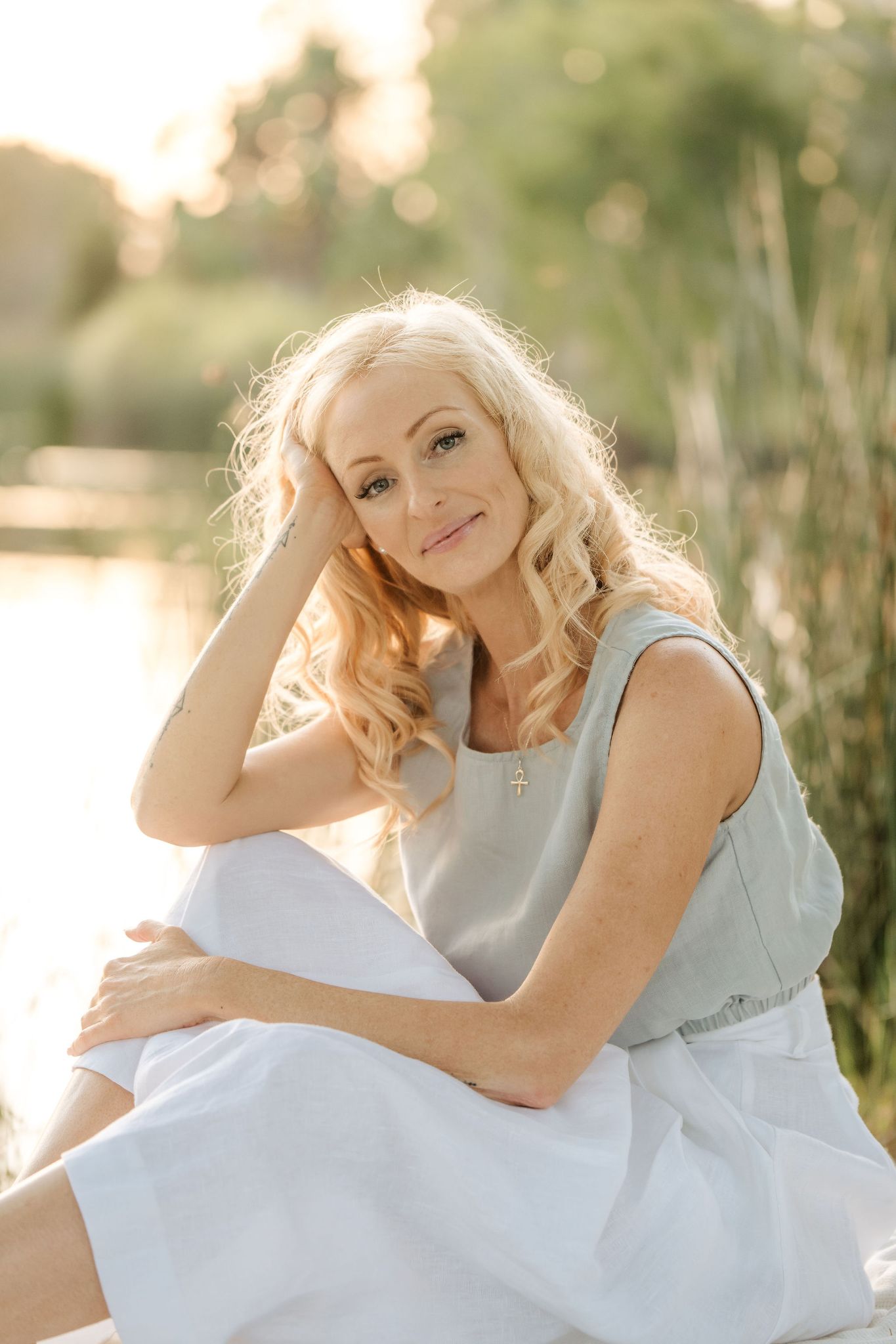 Angel Goodson-Adams sitting by the lake in golden light